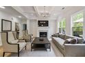 Bright and airy living room featuring a fireplace, coffered ceiling, and large windows at 3755 Valleyway Rd, Cumming, GA 30040