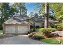 Charming home featuring a two-car garage and a well-manicured lawn with mature trees at 2100 Stone Hollow Ct, Marietta, GA 30062