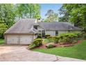 Charming home featuring a two-car garage and a well-manicured lawn with mature trees at 2100 Stone Hollow Ct, Marietta, GA 30062