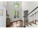 Bright, sunlit foyer featuring hardwood floors, glass paned door, and a staircase with a wood handrail at 4295 Parish Trce, Marietta, GA 30066