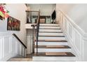 Elegant staircase featuring a decorative railing, wall paneling, and tiled entryway at 3140 Willow Park Dr, Dacula, GA 30019