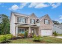 Traditional two-story home with brick accents, a covered porch, and a two-car garage at 328 Orchid Dr, Mcdonough, GA 30252