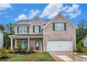 Beautiful two-story brick home featuring a cozy front porch and attached two-car garage at 328 Orchid Dr, Mcdonough, GA 30252