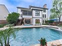 The backyard showcases a refreshing pool surrounded by a patio area, a screened porch, and lush greenery at 215 Haleys Ct, Woodstock, GA 30188
