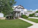 Traditional two-story home with a covered front porch, a well-kept lawn, and a paved walkway leading to the entrance at 215 Haleys Ct, Woodstock, GA 30188