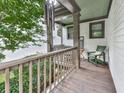 Cozy covered porch with wooden flooring, railings, and a comfortable chair perfect for relaxation and enjoying the outdoors at 215 Haleys Ct, Woodstock, GA 30188