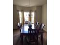 Elegant dining room with a wooden table, chandelier, and large windows with sheer curtains at 6074 Locklear Way, Douglasville, GA 30134