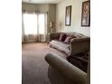 Cozy living room featuring a comfortable sofa, neutral tones, and natural light from the window at 6074 Locklear Way, Douglasville, GA 30134