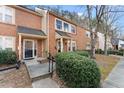 View of the brick townhomes with well-maintained landscaping and sidewalk access at 4418 Chowning Way, Dunwoody, GA 30338