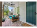 Close-up of the cozy front porch featuring a porch swing and brick flooring at 676 Juneberry Se Ln, Atlanta, GA 30316