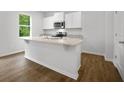 Kitchen features granite countertops, stainless steel appliances, white cabinets, island with sink, and hardwood floors at 8219 Coldstream Dr, Fairburn, GA 30213