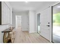 Bright entryway with white walls, wood-look floors, modern table and an exterior door with sidelight at 831 Sweet Briar Se Ln, Conyers, GA 30094