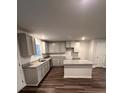 Modern kitchen boasts an island, gray cabinets, granite countertops, and stainless steel appliances at 30 Barton Ln, Covington, GA 30016
