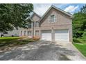 Two-story home with an attached two car garage and a double driveway at 1528 Rogers Crossing Dr, Lithonia, GA 30058