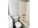 Clean bathroom featuring a shower-tub combo and a toilet with cabinet at 2115 Charter Ln, Lithonia, GA 30058