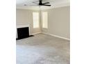 Open living room with a fireplace and abundant natural light from the large windows at 2115 Charter Ln, Lithonia, GA 30058
