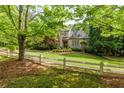Charming brick home featuring a manicured lawn, mature trees, and classic architectural details at 1575 Spalding Dr, Sandy Springs, GA 30350