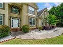 Inviting front entrance showcasing a white door, manicured bushes, and a concrete walkway with outdoor lighting at 209 Braemar Ct, Mcdonough, GA 30253