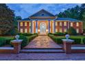 Stately brick home featuring manicured landscaping and a columned entrance at dusk at 4500 Candacraig, Alpharetta, GA 30022