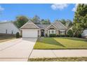 Charming home featuring a well-manicured lawn, attached garage, and inviting curb appeal at 352 Southgate Dr, Locust Grove, GA 30248