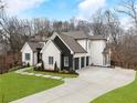 Elegant home with a spacious driveway, manicured lawn, and a sophisticated black and white exterior design at 120 Nezhat Pl, Atlanta, GA 30350