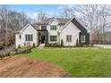 Beautiful two-story home featuring fresh green lawn, landscaping, and a striking black and white exterior at 120 Nezhat Pl, Atlanta, GA 30350