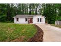 One-story home featuring fresh landscaping, wood shutters, and a charming red front door at 1563 Brannon Sw Cir, Austell, GA 30106