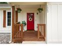 Inviting covered front porch with red door, hanging plants, and decorative wreath at 1563 Brannon Sw Cir, Austell, GA 30106