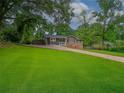 Single-story house featuring a well-manicured lawn, charming facade, and an inviting driveway at 6892 Autumn Hills Dr, Douglasville, GA 30135