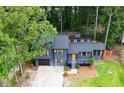 Aerial view of a modern two-story home with a black garage door and yellow door, surrounded by mature trees at 805 Wayside Dr, Lawrenceville, GA 30046