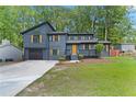 Beautiful two-story home with a modern gray exterior, a black garage door and yellow door, complemented by a green lawn at 805 Wayside Dr, Lawrenceville, GA 30046