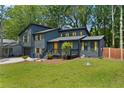 Charming two-story home with a well-manicured lawn and natural wood accents and a yellow front door at 805 Wayside Dr, Lawrenceville, GA 30046