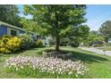 Lush front yard with a large tree and colorful flowers at 1030 Brockdell Ct, Norcross, GA 30093