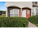 Inviting townhome entrance with a charming round window and well-kept shrubbery at 6099 Camden Forrest Cv, Riverdale, GA 30296