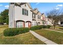 Row of townhomes each with a manicured lawn and sidewalk to the front doors at 6099 Camden Forrest Cv, Riverdale, GA 30296
