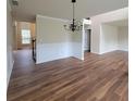 Inviting open-concept living area with hardwood floors, a chandelier, and a view of the staircase to the second floor at 1474 Union Station, Lawrenceville, GA 30045