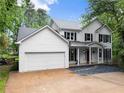 Charming two-story home with white siding, black shutters, red front door, and a well-manicured lawn at 1620 Bluewater Ct, Cumming, GA 30041