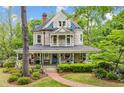 Beautiful two-story home featuring a wrap-around porch and well-manicured lawn at 185 Elizabeth St, Atlanta, GA 30307