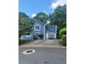 Inviting two-story home with blue siding, white trim, and a spacious driveway framed by lush trees at 4157 Lake Mist Nw Dr, Kennesaw, GA 30144