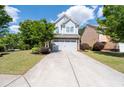 A well-manicured lawn and landscaping complement this two-story home with a gray garage door at 2341 Lily Valley Dr, Lawrenceville, GA 30045