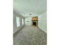 Cozy living room with plush carpeting and a stone fireplace at 589 Catrina Ct, Stone Mountain, GA 30087