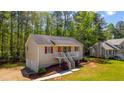 Traditional-style home with a welcoming porch and a well-maintained lawn nestled in a wooded setting at 379 Villa Rosa Way, Temple, GA 30179