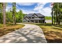 Spacious home with a long driveway surrounded by lush greenery and blue sky at 415 Paynes Lake Rd, Carrollton, GA 30116