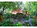 Serene backyard oasis with a pond, waterfall feature, and lush greenery at 745 Devon Hill Ct, Roswell, GA 30075