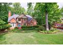 Stunning brick home boasts a lush front lawn and mature trees in a desirable neighborhood at 745 Devon Hill Ct, Roswell, GA 30075