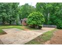 Wide concrete driveway leading to a charming home surrounded by lush greenery at 2675 Kellogg Creek Rd, Acworth, GA 30102