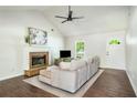 Bright living room featuring a cozy fireplace, vaulted ceilings, hardwood floors, and a neutral color palette at 45 Pine Tree Dr, Mcdonough, GA 30252