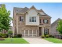 Inviting two-story brick home with a well-kept lawn, two-car garage, and appealing architectural details at 2251 Nancy Creek Dr, Atlanta, GA 30341