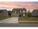 Lovely home showcases manicured lawn, long driveway and inviting sunset at 537 Daffodil Ln, Mcdonough, GA 30253