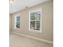 Bright bedroom featuring neutral walls, plush carpeting, and windows offering pleasant neighborhood views at 933 Catamaran Ct, Alpharetta, GA 30005